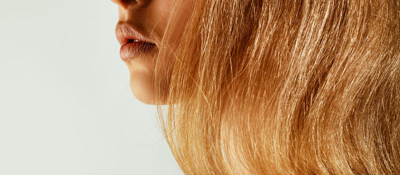 Side profile of a woman's face and jawline in natural light