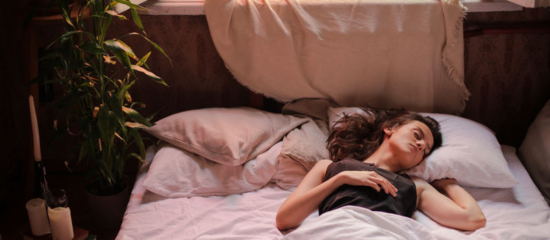 Woman sleeping in a sunlit bedroom