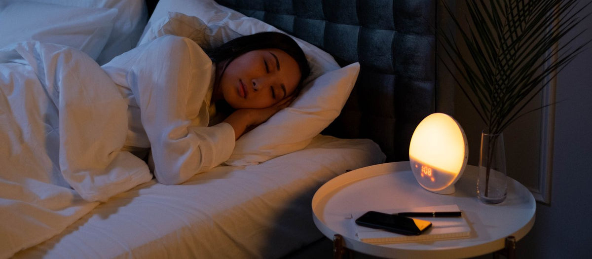 Woman sleeping peacefully in a softly lit bedroom