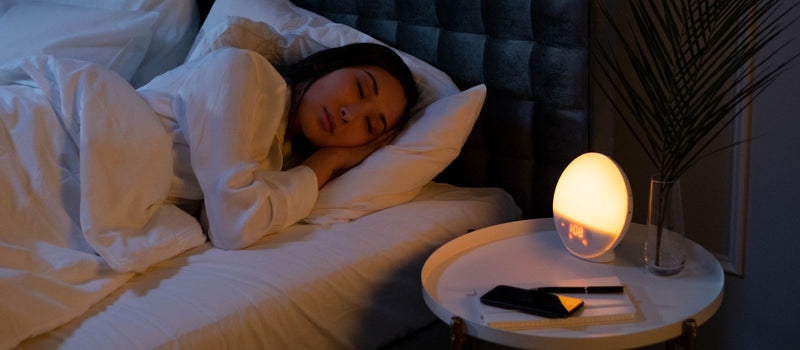 Woman sleeping peacefully in a softly lit bedroom